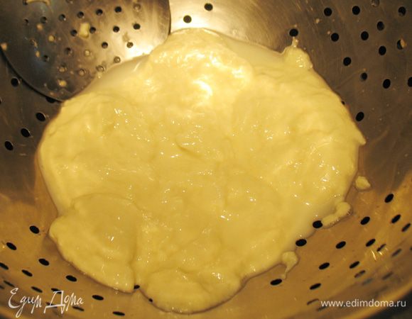 Перекладываем сгусток руками или шумовкой в дуршлаг. Дать стечь сыворотке, можно слегка надавливать руками. Вернуть сыворотку обратно в кастрюлю.   Часть сыворотки налить в контейнер посолить по вкусу и охлаждаем.  