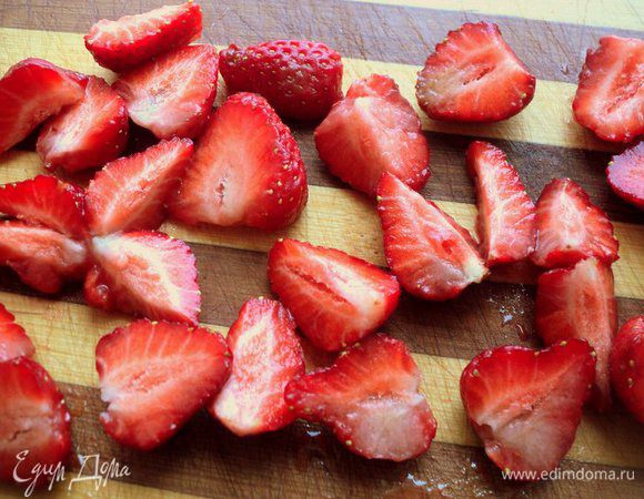 Клубнику помыть, обсушить на бумажной салфетке, очистить от хвостиков и порезать на четвертинки или пополам,  в зависимости от величины клубники.