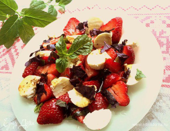 Выложить на тарелку клубнику, кусочки сыра, полить заправкой, посыпать мелко нарезанными листиками базилика (фиолетового или зеленого). Приятного аппетита!