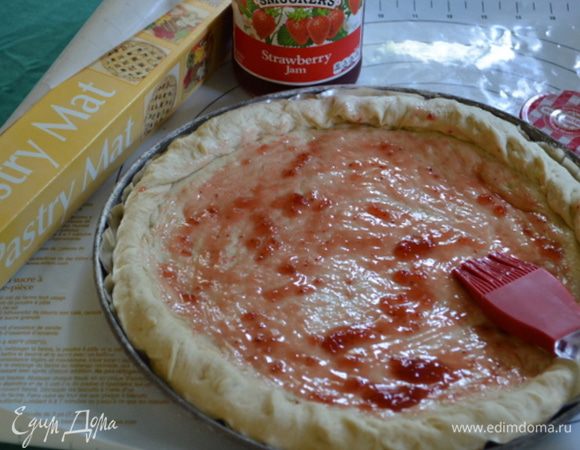 В это время приготовим фрукты, помоем и очистим, разрежем на части. Яблоки можно с кожурой и тонко нарезанные. Сбрызнем лимонным соком.
Тесто выложим на рабочую припыленную мукой поверхность, помять.  Раскатать в круг под вашу форму. Выложить ее в форму, бортики поднять.
Смажем поверхность кисточкой клубничным джемом.