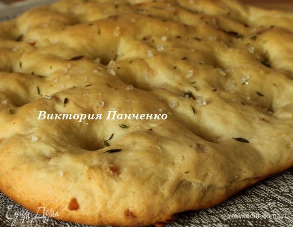 Выпекать 25-30 минут до светло-золотистого цвета. Достать из духовки и охладить на решетке. Пока фокачча еще горячая, смазать ее оливковым маслом.