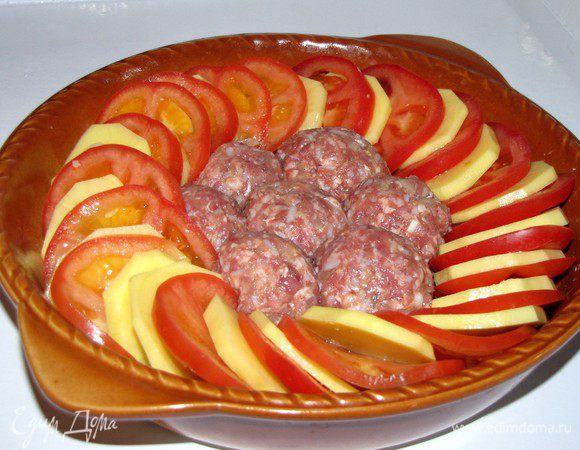 Картофель и помидоры нарезать тонкими кружками и выложить вокруг тефтелек, чередуя.