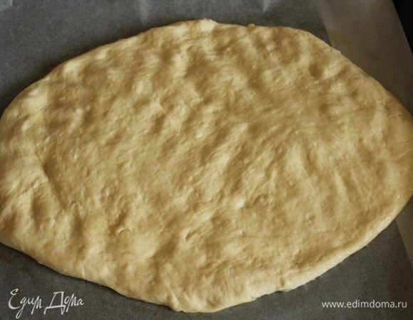 Противень выстелить пекарской бумагой, выложить тесто и равномерно распределить, приминая тесто кончиками пальцев. Оставить на 45 минут.