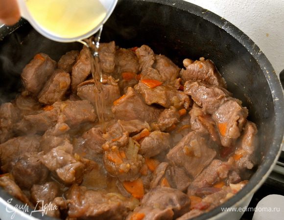 Влить в мясу белое сухое вино и продолжить тушить мясо, пока не выпарится алкоголь (около 10 минут).  