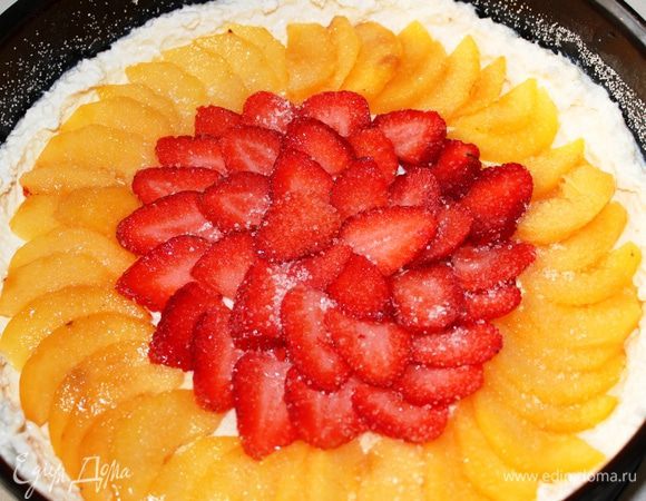 Персики очистить от кожицы, нарезать на тонкие пластинки и разложить по внешней окружности. Ближе к центру разложить нарезанную клубнику. Фрукты можно присыпать дополнительно одной ложкой сахара