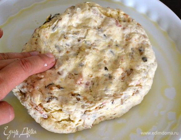 Готовое тесто выложить в смазанную оливковым масло форму (28 см) и распределить по форме. Накрыть полотенцем и поставить в защищенное от сквозняков тихое место на 2 часа. 