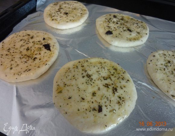 Подошедшее тесто обмять, хорошо вымесить на рабочей поверхности, муку не добавлять, затем разделить тесто на 4-5 частей, скатать шарики, раскатать лепешки (1 см. толщиной). Выложить на смазанный маслом противень, сверху лепешки смазать немного ароматным маслом. Оставить на 30 минут на столе для расстойки, прикрыв бумажным полотенцем.