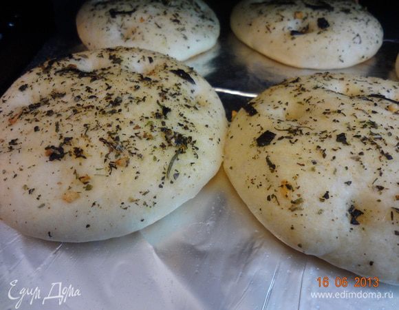 Через 30 минут в лепешках сделать пальцами несколько углублений и смазать всю поверхность оставшимся ароматным маслом, посыпать морской крупной солью, оставить еще на 15 минут на столе. Разогреть духовку до 220 С. Через 15 минут лепешки отправить в духовку на 10-15 минут, до легкого зарумянивания.