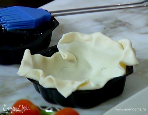 Небольшие формы для выпечки смазать оливковым маслом и выложить в них тесто так, чтобы свешивались края.