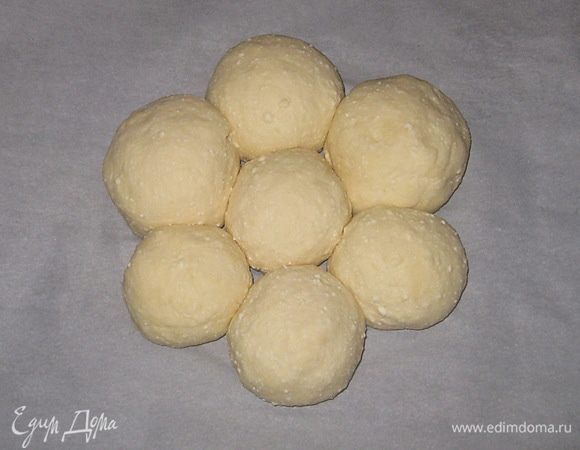 Разрезать тесто на семь равных частей. Сформировать шарики и выложить на пергамент  в форме ромашки. Оставить на 15-20 минут для подъема. 