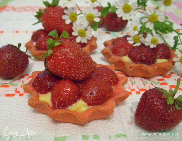 В охлажденные тарталетки выложить крем, разровнять, сверху уложить клубнику.