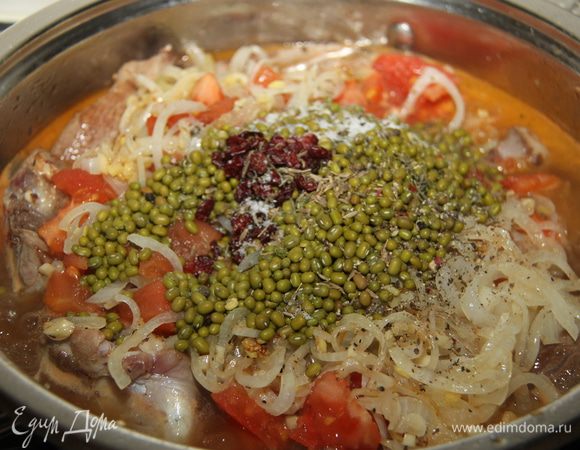 Выложить на мясо лук, помидоры, маш. Налить кипящую воду, чтобы покрыло мясо, примерно 1 стакан. Посыпать зирой, тимьяном, перцем, барбарисом, посолить. Закрыть крышкой, уменьшить огонь до минимума и тушить в течение 1 часа. 