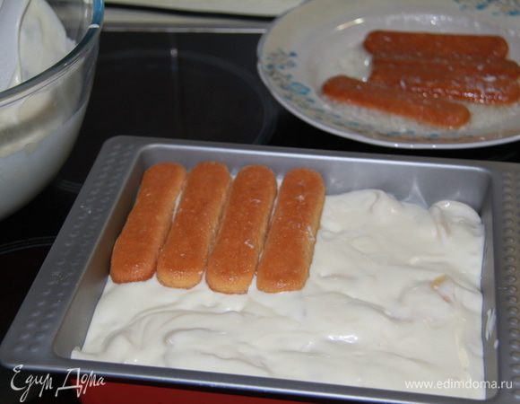 Замочить каждую печенюшку в персиковом сиропе. Выложить в форму слой печенья. Затем слой крема. Повторяем, пока не закончится печенье и крем. 