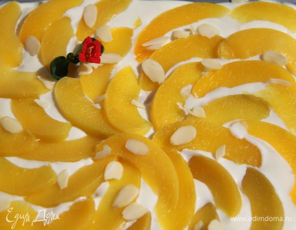 Верх украсить дольками персика и миндальными лепестками. Оставить в холодильнике на 2-3 часа.