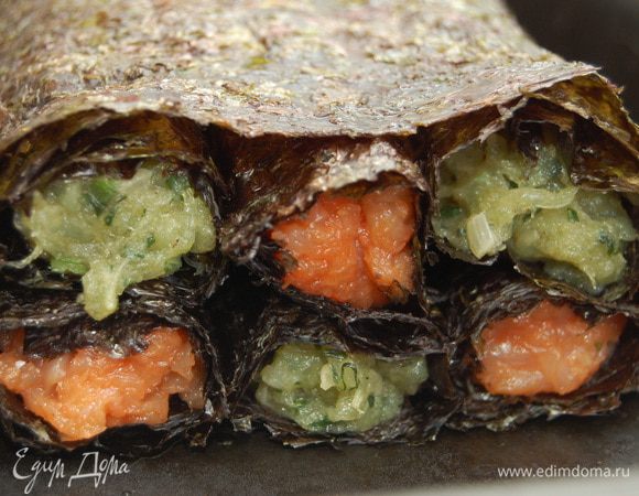 На противень положить пергамент, сверху лист нори, а него в два ряда (в шахматном порядке) выложить рулеты, сверху еще один лист нори.  Листы лучше немножко смочить водой, чтобы они приклеились к рулету. Выпекать  около 30 мин при температуре 190 градусов. В процессе приготовления рулет выделит сок, его можно использовать как соус.  Готовую запеканку слегка остудить и разрезать порционно.