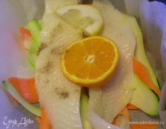 Делаем 2 конвертика из бумаги для выпечки. На нее (можно его немного смазать маслом) выкладываем овощи. Затем рыбное филе. Сверху по дольке лимона и апельсина. Посыпаем имбирем (по 1 ч.л.) и взбрызгиваем вином (по 1 ст.л.). Закрываем конвертики. Ставим в духовку 190 гр на 20-25 минут до готовности рыбы.
