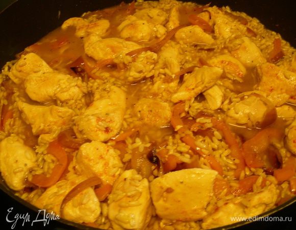 Добавляем курицу обратно к рису. Доводим до кипения, уменьшаем огонь, накрываем крышкой и готовим минут 20.
