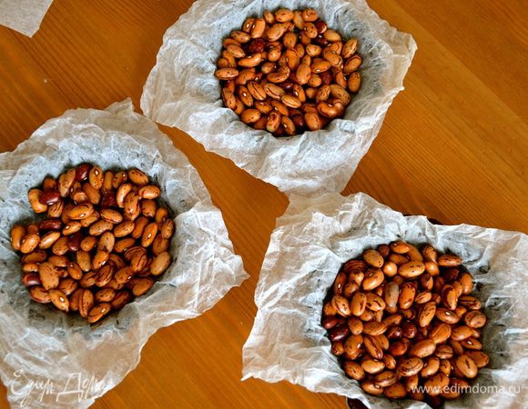 ....покрыть каждую формочку вырезанным квадратом пекарской бумаги, предварительно смоченной в воде и как следует отжатой, сверху выложить фасоль (или любой другой используемый Вами для этих целей "утяжелитель"). Выпекать в заранее разогретой до 180 С духовке 15-20 минут. Затем снять бумагу с фасолью и выпекать еще 5 мин. Готовые основания тарталеток достать из духовки и дать остыть, после чего освободить их от формочек. 