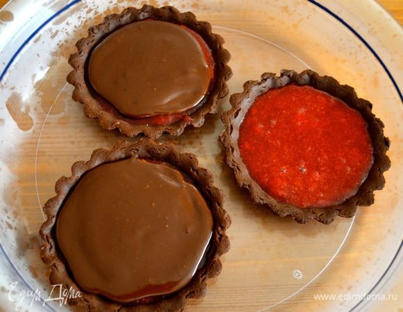 Готовые тарталетки заполнить клубничным желе и убрать в холодильник примерно на 1 час. Затем добавить сверху по 2 ст. ложки шоколадного крема, и снова убрать охлаждаться на 1 час.   