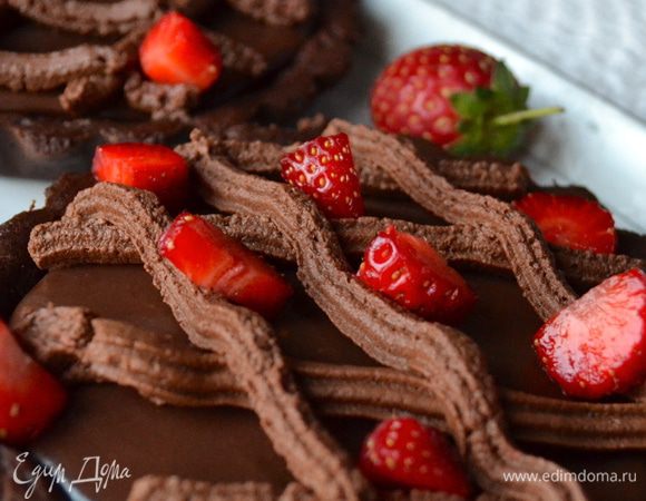 Остатки шоколадного крема (со сливками) взбить, и с помощью кондитерского мешка нанести на тарталетки узор "решеткой" (наподобие маленькой кростаты)))) Украсить оставшейся клубникой, нарезав ее маленькими кусочками.