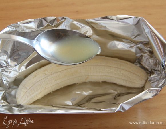 Банан очистить. Из двух слоёв фольги сделать подобие лодочки с высокими бортиками. Уложить туда банан. Полить банан лимонным соком.