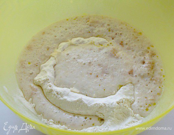 Муку вместе с солью просеять на стол или в миску, сделать в центре углубление, влить оливковое масло и молоко с дрожжами. Вымесить тесто.