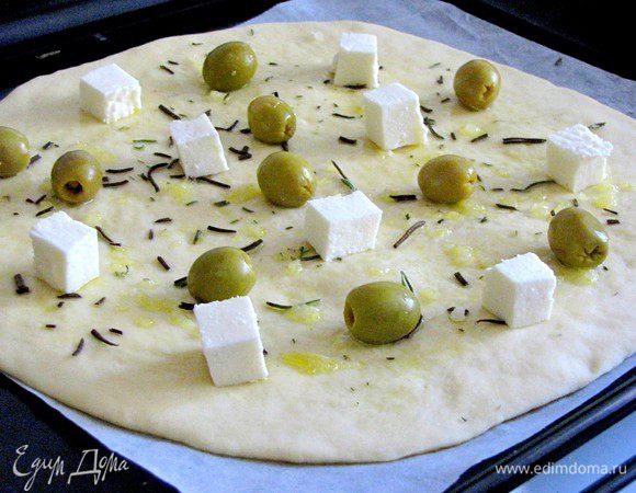 Посыпать любимыми травами (у меня розмарин), добавить раздавленные зубчики чеснока, положить кусочки сыра и оливки.