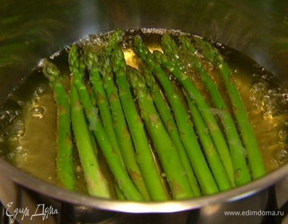 У спаржи отломить грубые черенки и отправить ее на несколько минут в кипящую воду. Затем воду слить, промыть спаржу в ледяной воде и выложить на бумажное полотенце.