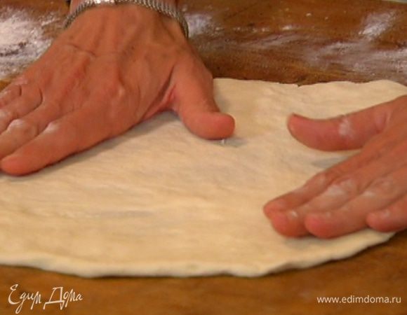 Рабочую поверхность посыпать оставшейся мукой и раскатать из теста тонкий пласт.