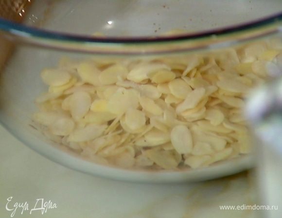 Миндальные хлопья (немного оставить) соединить с измельченными специями, всыпать муку, разрыхлитель, сахар и соль, все перемешать.