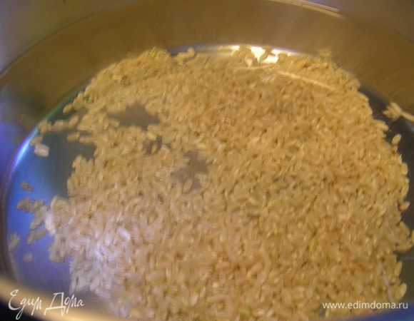 В кастрюлю наливаем бульон (или воду), всыпаем рис и готовим на среднем огне до полуготовности.
