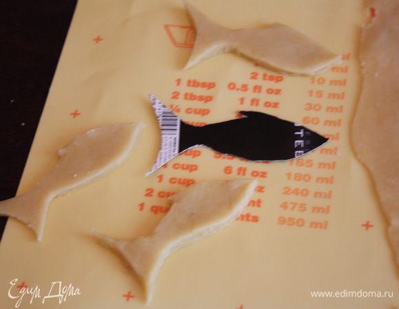 Оставшуюся часть теста раскатаем также тонко и вырежем на нем рыбки по шаблону и для украшений. Можете ничего не вырезать, а просто сделать пару отверстий в пироге.