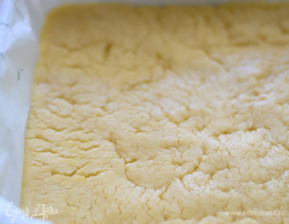 Форму застелить пекарской бумагой. Тесто (ту часть, что больше) выложить на пергамент,разровнять хорошенько руками и наколоть вилкой.Отправить в духовку и выпекать 20 минут.