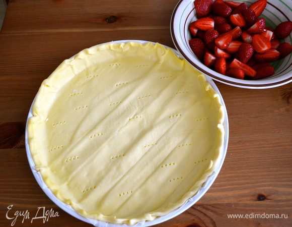 Подготовить пласт готового слоеного теста (за неимением домашнего...) выложить в форму для выпечки, сделать вилкой дырки. Клубнику вымыть и разрезать пополам (очень крупную я разрезала на четвертинки).  