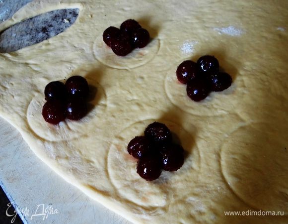 Стаканом, или чашкой нанести примерный контур мандрыка и выложить несколько вишен на тесто. 