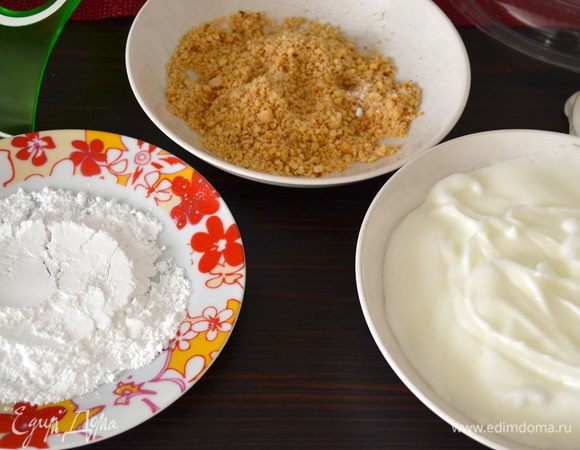 Подготовить три глубоких тарелки. В одну насыпьте 40 г сахарной пудры (может потребоваться и больше!), в другую положить взбитые белки, а в третью насыпать мелко порубленные орехи.  