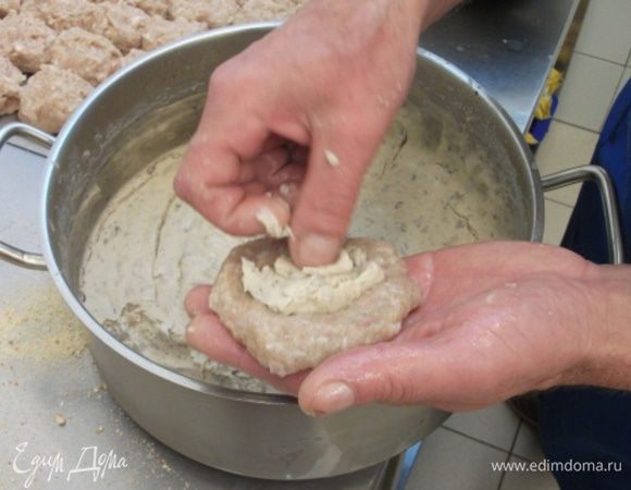 К куриному фаршу, по желанию, добавляем молотый лук и делим на котлетки.
Мокрыми руками делаем из фарша "пирожки" и кладем внутрь молочный соус. После охлаждения он довольно упругий и эластичный.