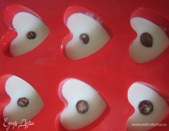 Творожную массу разлить по силиконовым формочкам У меня сердечки.Мне захотелось сделать срединку. На тёрке натёрла шоколад с клубничным наполнителем. Скатала шарики и поместила в срединку. Такой вот сюрприз)).