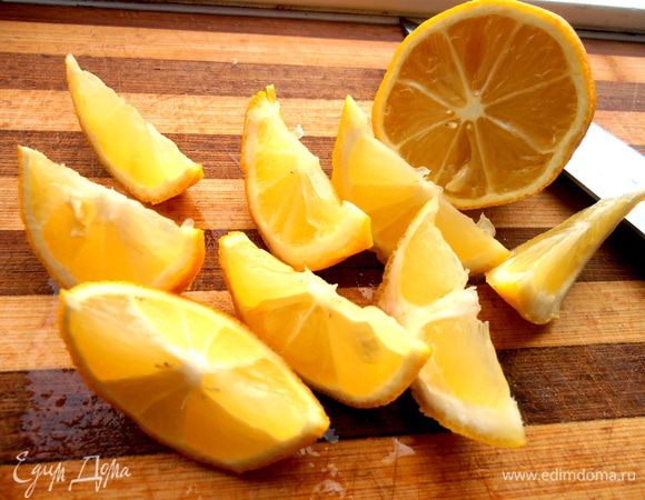 Лимон моем и нарезаем прямо с кожурой на ломтики.