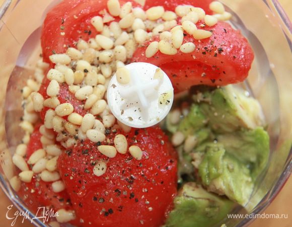 С помидоров снять кожицу, нарезать кусками. Авокадо, помидоры, кедровые орехи, масло, лимонный сок, соль и перец сложить в кухонный комбайн и взбить в течение 2 минут. 