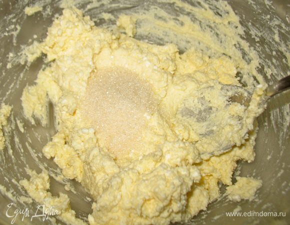 В творожно-маслянную массу добавляем сахар, ванильный сахар. Перемешиваем. 