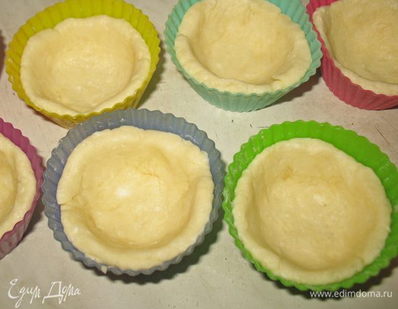 Тесто делим на комочки и раскатываем в кружочки. Кружочки раскладываем по формочкам. Формочки с тестом ставим в морозилку на 5-10  минут.