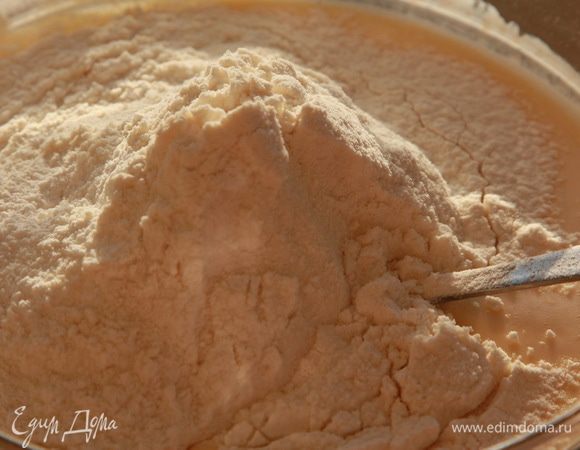 Добавляем сахар, сметану и эссенцию. Тщательно взбиваем. Просеиваем муку в смесь, добавляем разрыхлитель