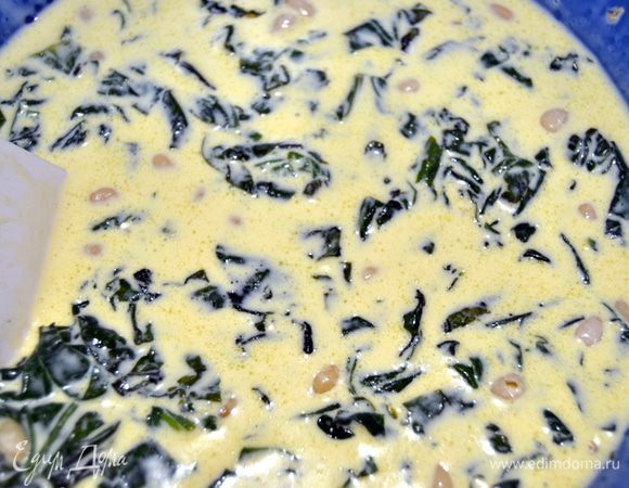 В сливочно-яичную смесь выложить шпинат, изюм вместе с бренди и орехи.