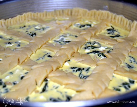 Из оставшейся части теста делаем ленты. Предварительно раскатав тесто в прямоугольник. На каждой ленточке, по всей длине делаем надрезы. Выкладываем ленты на пирог в виде решетки. Предварительно края теста нужно смазать водой. Излишки теста обрезать. Отложенным взбитым яйцом смазать открытые участки теста.