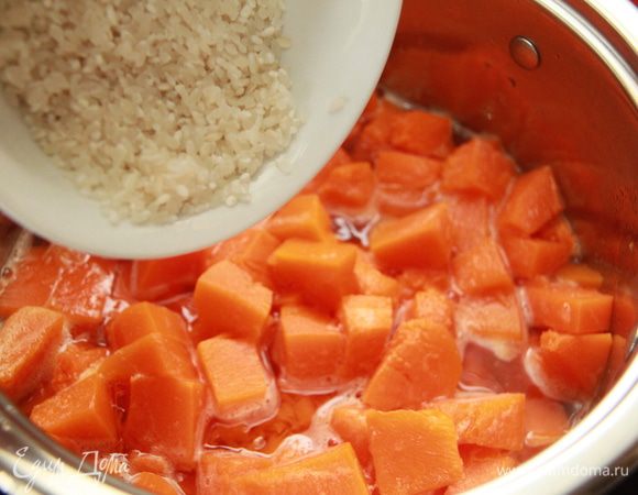 Тыкву нарежьте на кубики, положите в кастрюлю. Засыпьте промытый рис. Залейте кипятком и томите 20 минут.