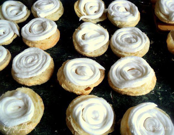 Пирожные вынуть из духовки, остудить и разрезать вдоль пополам. Выложить пышный слой белкового крема. 