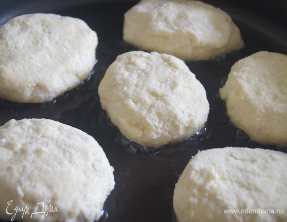 Защипать творожную массу вокруг вишни, сформировать сырники, обвалять их в муке или манной крупе. Обжарить сырники на разогретой сковороде с растительным маслом до золотистой корочки.