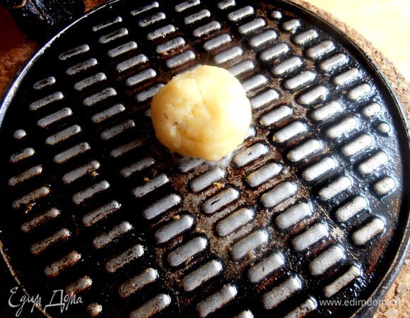 В это время уже разогревается на небольшом огне вафельница. Смазываем её обе стороны растительным маслом и кладём в центр один шарик.