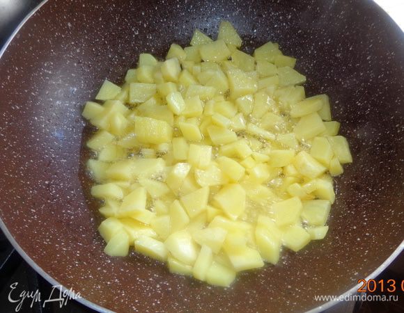 Нарезать ломтиками картошку и обжарить ее. Выложить в кастрюлю.